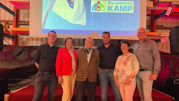 Familie Kamp mit dem neuen Logo der i&M-Markengemeinschaft für das Unternehmen im Hintergrund (v. l.): Kai Kamp, Christel Kamp, Ewald Kamp senior, Patrick Kamp, Birgit Kamp, Ewald Kamp junior.