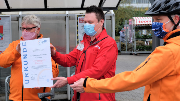 Vorstandssprecher Herbert Fürmann (links) und Jörg Walther (rechts) vom ADFC überreichten die Urkunde an Toom-Marktleiter Matthias Schwucht. 