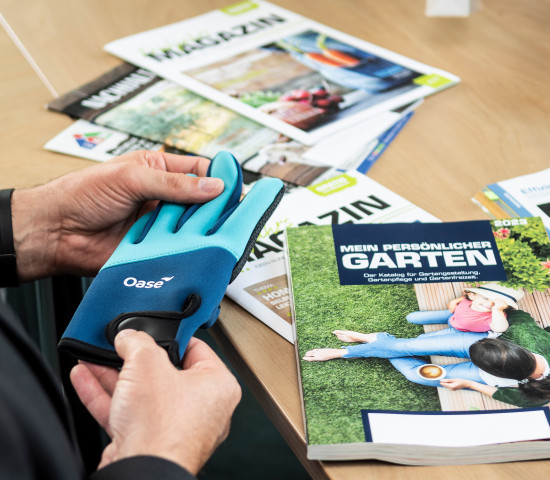 Neue Produkte – wie hier ein Neoprenhandschuh für die Pflege im Gartenteich – und Kataloge oder Prospekte werden gemeinsam besprochen.