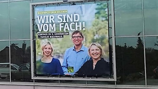 Die Familie Buchwald zeigt Gesicht: Auf einem großflächigen Fassadenbild begrüßen die neuen Inhaber ihre Kunden.
