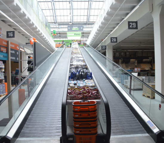 Ein Fahrsteig - eine Rolltreppe ohne Stufen - verbindet die Geschosse.