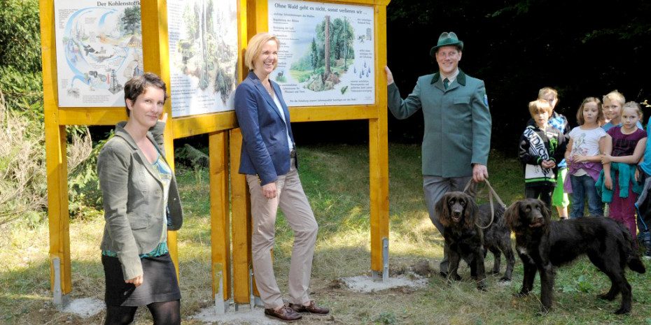 Herz und Mittelpunkt des Schulungswaldes ist der zentral gelegene Infopoint mit sechs Lerntafeln. Auf dem Bild Erika Müller vom FSC Annette Rauber, Marketingverantwortliche für die Holz­schutz­­marke Xyladecor und Consolan, sowie der Heidenroder Revierförster Volker Diefenbach.