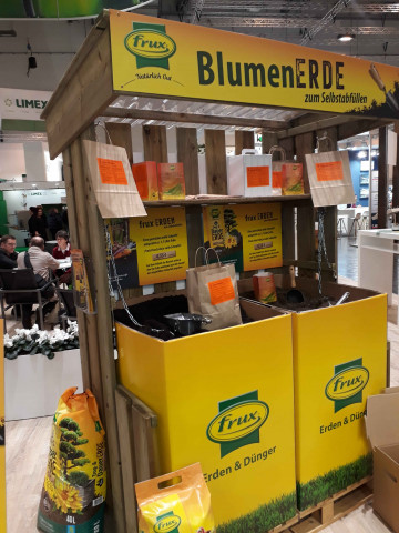 Stand der Fachhandelsmarke Frux, die die erste Selbstbedienungsstation zum Abfüllen von Blumenerde im Gartencenter zeigt.
