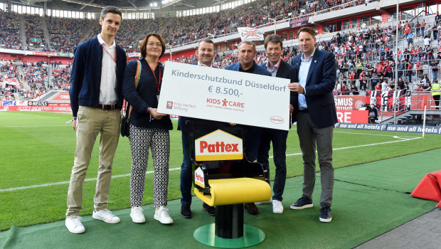 Daniel Beckers, Pattex-Brand Manager (von links), Bettina Erlbruch vom Kinderschutzbund, Robert Klimczak, Geschäftsführer der Soplid GmbH, Klaus Allofs, Vorstand bei Fortuna Düsseldorf, Alexander Pieper, Leiter Sponsoring bei Henkel und Christian Koke, Vorstand Marketing bei Fortuna Düsseldorf, bei der Übergabe von Trainerstuhl und Spendenscheck.