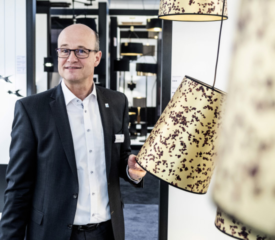 Eglo-Geschäftsführer Andreas Kuhrt zeigt Lampen mit Rosenblättern.