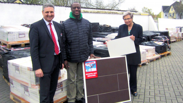 Dr. Samuel Okae (M.) und Hannelore Bauer haben die mehr als 2.000 m² Fliesen von Hellweg-Marktleiter Martin Niewerth in Empfang genommen.