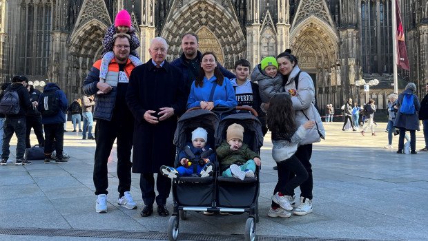 John Herbert (2. v. l.) zusammen mit den beiden geflüchteten Familien vor dem Kölner Dom.