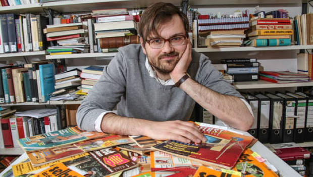 Jonathan Voges vor einer Auswahl "historischer" Heimwerkerzeitschriften (Foto: Leibniz Universität Hannover).