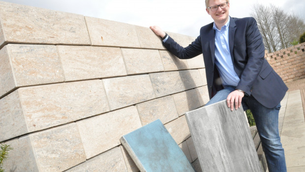 Geschäftsführer Theo Diephaus jr. mit seinem preisgekrönten Produkten, der Gartenmauer Tosa und der beschichteten Terrassenplatte Latio. Foto: Stefan Freiwald
